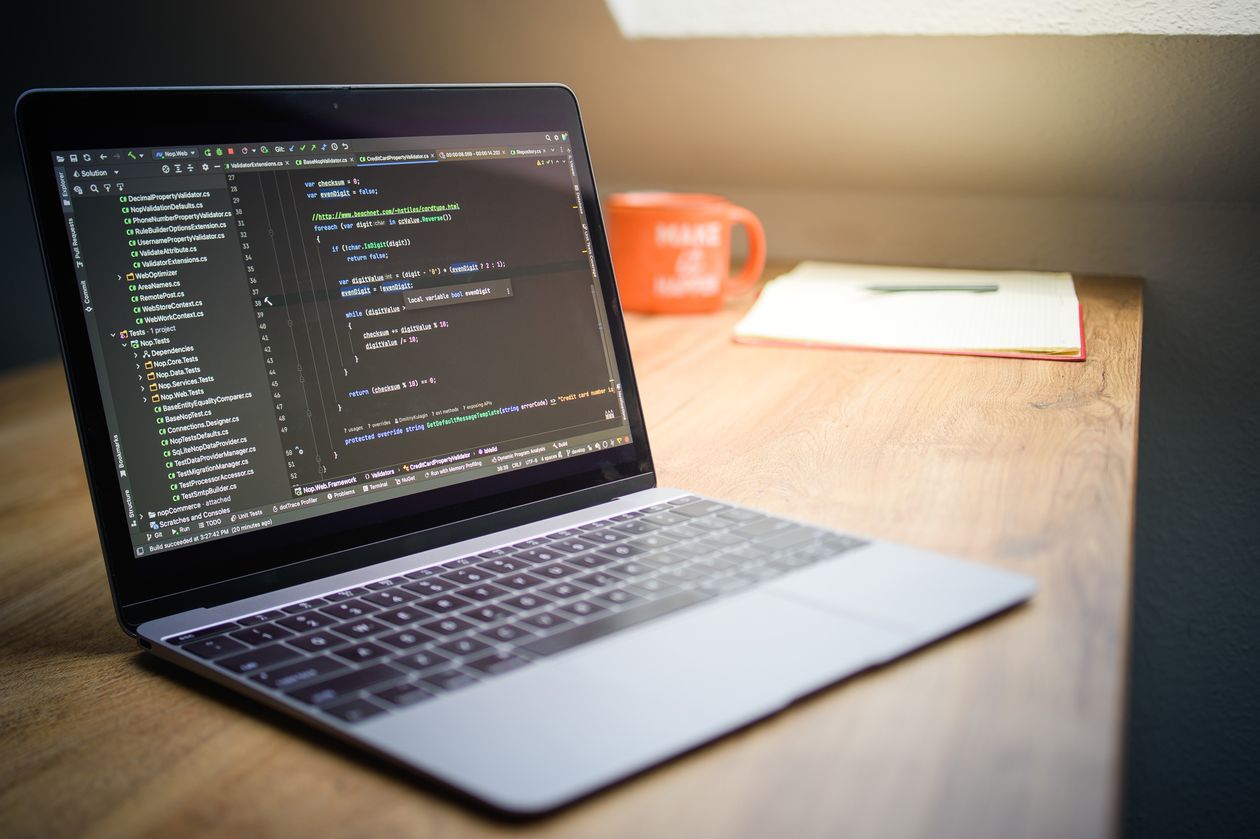 Laptop displaying source code on a wooden desk, illustrating AI coding agent security