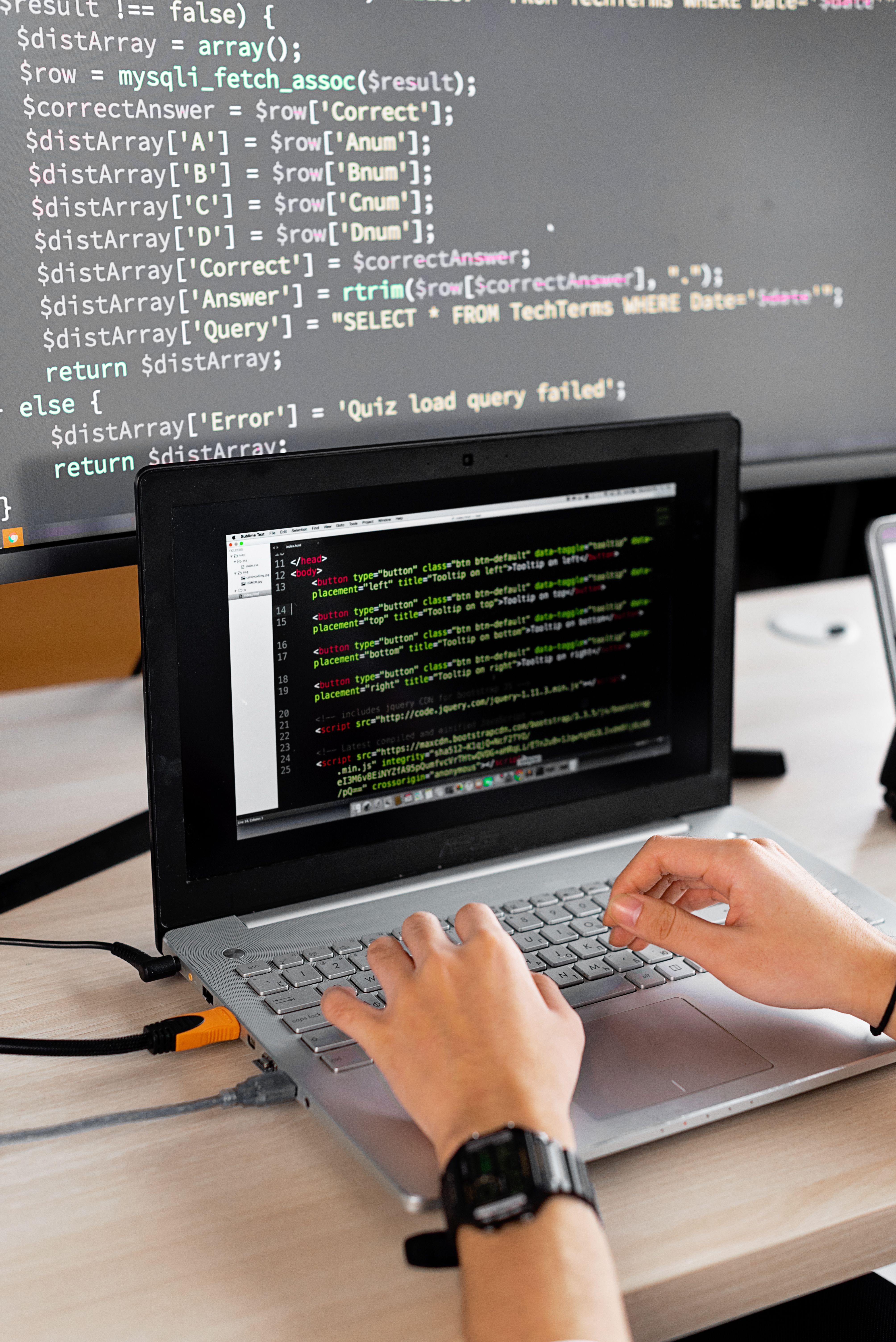 Cybersecurity engineer reviewing code on computer monitors